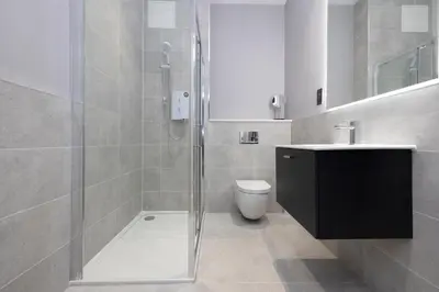 a bathroom with a shower and a toilet and a sink at JOIVY Modern Studio in New Town, on Historic George Street in Edinburgh