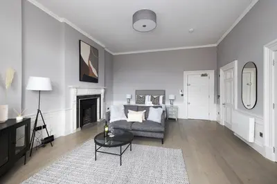 a living room with a couch and a fireplace at JOIVY Modern Studio in New Town, on Historic George Street in Edinburgh