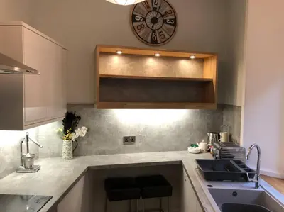 a kitchen with a sink and a clock on the wall at Pier Head in Largs
