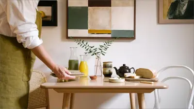 a person standing next to a table with a table at The Dundonald Guesthouse & Cottage in Culross