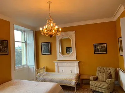 a bedroom with a bed and a mirror and a chandelier at 2 Chester St in Edinburgh