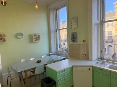 a kitchen with a table and a table and a window at 2 Chester St in Edinburgh