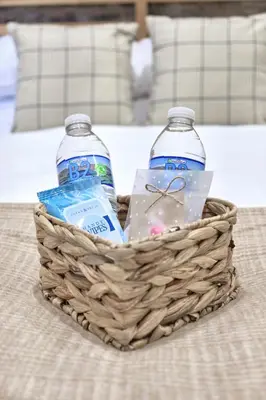 two bottles of water in a basket on a bed at Seòmar Beag in Oban