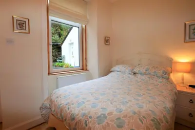 a bedroom with a bed and a window at Kames View Apartment in Tighnabruaich