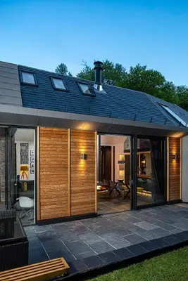 a home with a patio and a house with sliding glass doors at Roselea Cottage in Luss