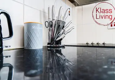 a vase with scissors on a counter in a kitchen at Garturk Apartment by Klass Living Coatbridge in Coatbridge