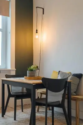 a dining room table with two chairs and a table and a lamp at The Trossachs Apartment in Doune