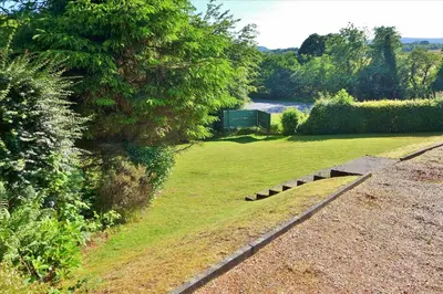 a garden with a grassy yard with a tree at Allandale House in Brodick