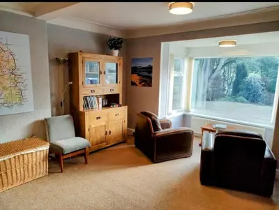 a living room with two chairs and a window at Allandale House in Brodick