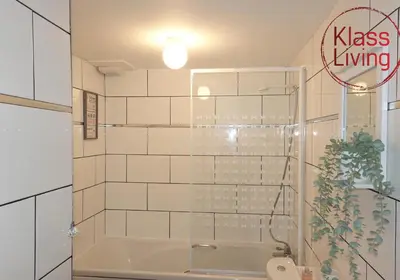 a bathroom with a tub and a toilet and a sign at Mossend Apartment by Klass Living Bellshill in Mossend