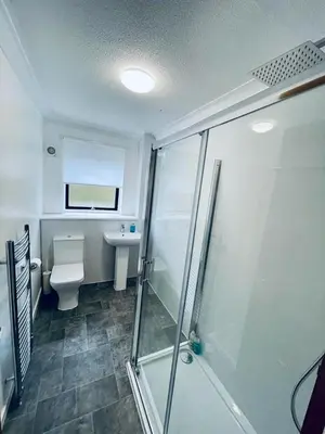 a bathroom with a shower and a toilet and a sink at Modern 2 Bedroom Apartment With Free Parking in Glasgow