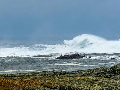 a large wave in the ocean on a beach at Burnside Cottage in Bruichladdich