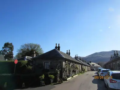 a row of houses on a street in a village at Levenside Holiday Apartment, Balloch, Loch Lomond in Balloch