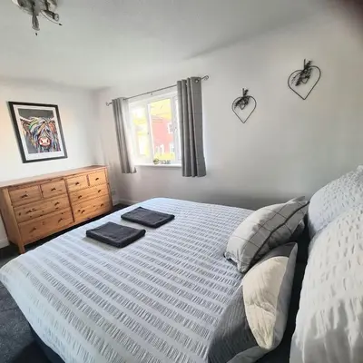 a bedroom with a bed with two towels on it at Levenside Holiday Apartment, Balloch, Loch Lomond in Balloch