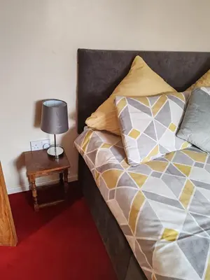 a bedroom with a bed and a table with a lamp at Wallace View - Holiday Home in Stirling