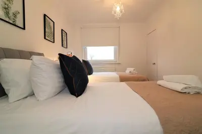 a bedroom with two beds and a window at Signature - North View in Cambusnethan