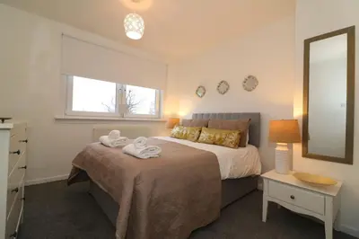 a bedroom with a bed with towels on it at Signature - North View in Cambusnethan