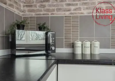 a kitchen with a black counter top with a microwave at Berwick Apartment by Klass Living Coatbridge in Coatbridge
