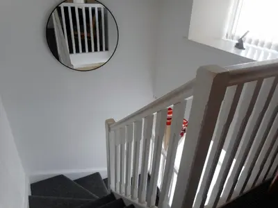 a mirror hanging on a wall next to a staircase at THE COACH HOUSE in Moffat