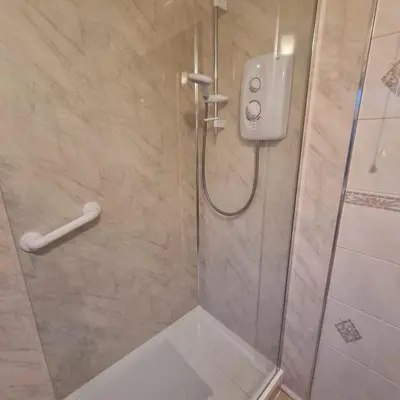a bathroom with a shower with a glass door at PREMIER - Whifflet Apartment in Coatbridge