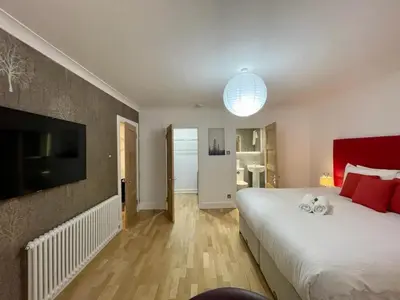 a bedroom with a large bed and a television at Elite 3 Bed New Town Apt with Private Walled Garden in Edinburgh