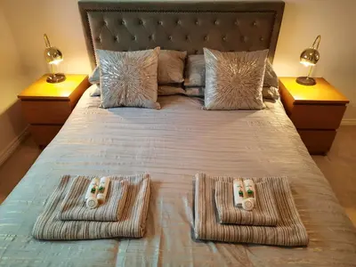 a bed with two game controllers on top of it at Pond View Upper in Airdrie