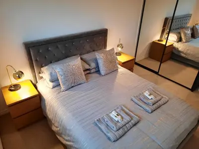 a bedroom with a bed with two towels on it at Pond View Upper in Airdrie