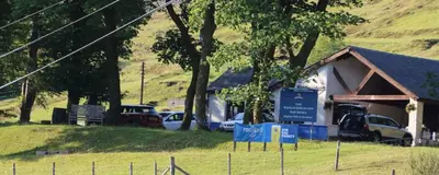 a building with cars parked in a field at Rowan Cottage Wanlockhead Dumfries & Galloway in Wanlockhead