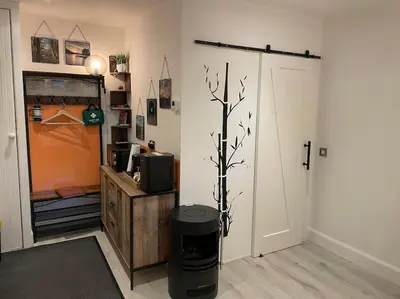 a living room with a tv and a tree in it at The Den - your cosy sleepover space in Saint Fillans