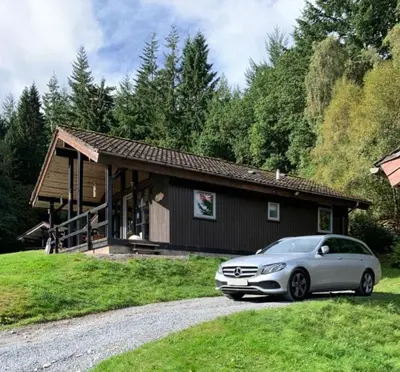 a car parked in front of a house at Milton Bay Luxury lodge wrapped in exceptional scenery in Morenish
