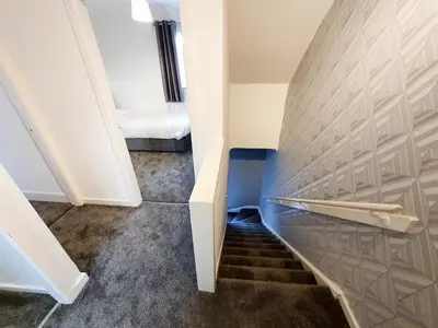a hallway with stairs with a bed in a room at 3 bedroom house Amazon M90 Dunfermline Edinburgh in Fife