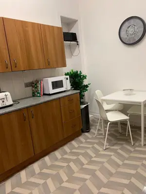 a kitchen with a microwave on the counter and a table at clyde hub in Gourock