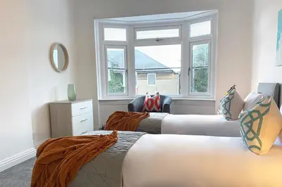a bedroom with two beds and a window at Gladsmuir House in Glasgow