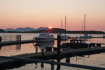 a group of boats docked at a dock at sunset at Newly refurbished town centre apartment in Oban