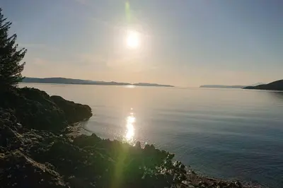 a large body of water with the sun in the sky at Newly refurbished town centre apartment in Oban