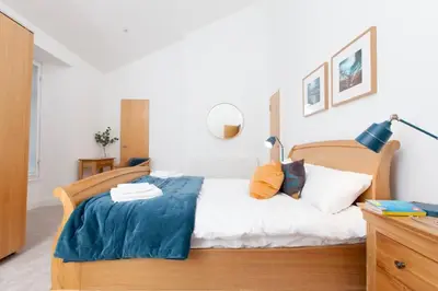 a bedroom with a bed with a blue blanket on it at Edinburgh Deluxe Duplex with Garage in Edinburgh