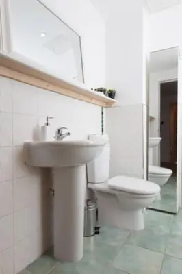a white bathroom with a sink and a toilet at Edinburgh Deluxe Duplex with Garage in Edinburgh