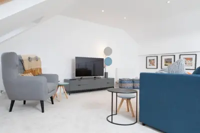 a living room with a couch and a tv at Edinburgh Deluxe Duplex with Garage in Edinburgh