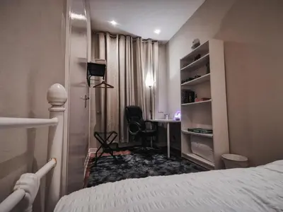 a bedroom with a bed and a desk with a chair at 3 bed apartment in the heart of westend of Glasgow in Glasgow