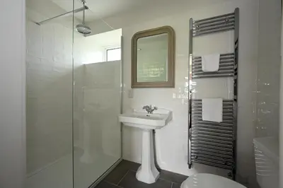 a white bathroom with a sink and a shower at Stormont House in Keilour