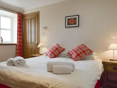 a bedroom with a white bed with towels on it at White Wisp in Kinross