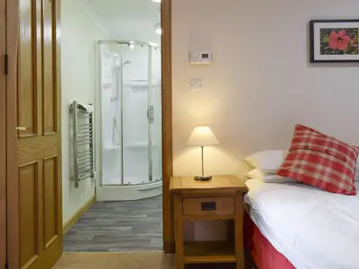 a bedroom with a shower and a bed and a lamp at White Wisp in Kinross