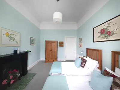 a bedroom with two beds and a fireplace at Stylish Central Edinburgh Apartment in Edinburgh