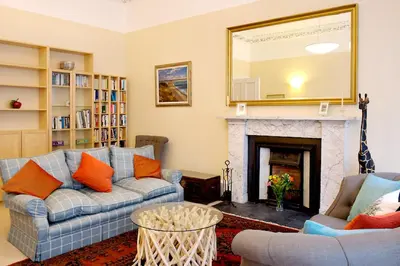 a living room with a couch and a fireplace at Stylish Central Edinburgh Apartment in Edinburgh