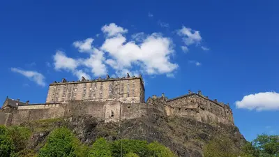 a castle sitting on top of a mountain at Stylish Central Edinburgh Apartment in Edinburgh
