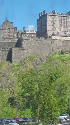 a large castle with cars parked in front of it at Stylish Central Edinburgh Apartment in Edinburgh