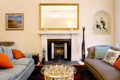 a living room with two couches and a fireplace at Stylish Central Edinburgh Apartment in Edinburgh