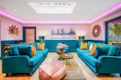 a living room with blue couches and yellow pillows at Enterkine Country House Resort in Annbank