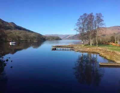a large lake with a dock in the middle at The Bothy - your unique luxury refuge in Saint Fillans