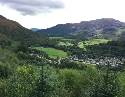 a town in the middle of a valley with mountains at The Bothy - your unique luxury refuge in Saint Fillans